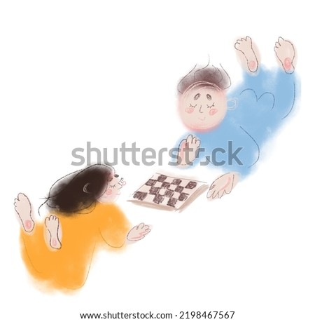 boy and girl playing chess laying down in pyjamas