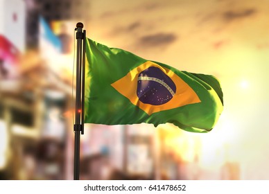 Brazil Flag Against City Blurred Background At Sunrise Backlight 3D Rendering - Powered by Shutterstock