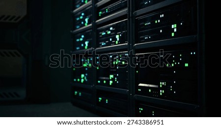 Bright green lights from data storage units create a glowing effect in a dimly lit room, showcasing the sophisticated technology and organized layout of electronic equipment.