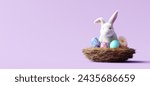 Bunny with Easter eggs in bird nest on purple background. 3d rendering