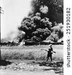 Burning oil tanks and cars left by retreating Dutch in Tandjong, Java. Ca. Feb.-Mar. 1942. World War 2.