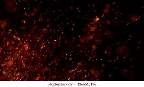 Burning red hot sparks fly from large fire in the night sky. Beautiful abstract background on the theme of fire, light and life. Burning embers glowing flying away particles over black background.