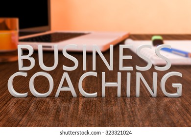 Business Coaching - Letters On Wooden Desk With Laptop Computer And A Notebook. 3d Render Illustration.