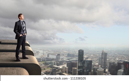 Business Man Standing High Over A Cityscape