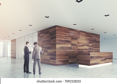 Business People Ina Wooden Panel And White Office Lobby With A Glass Wall Open Space Room And A Wooden Reception Counter. Side View 3d Rendering Mock Up