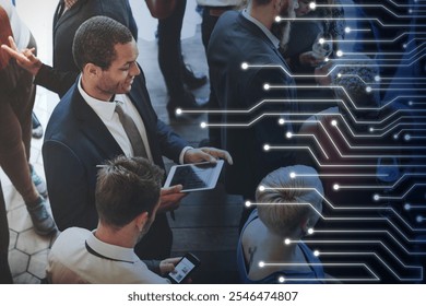 Business professionals networking at a tech event. Diverse group engaged with digital devices, technology and innovation in a corporate business meeting setting. Diverse business meeting concept. - Powered by Shutterstock