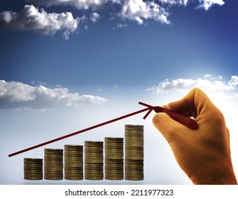 Businessman drawing an arrow over stack of coins - income growth concept