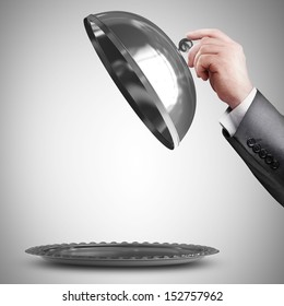 businessman hand holding silver platter or cloche with space to place object 