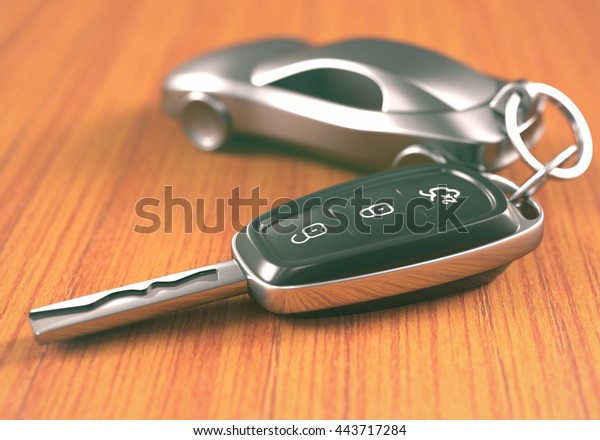 Car\
key with a car shaped keychain, on a wooden\
table.