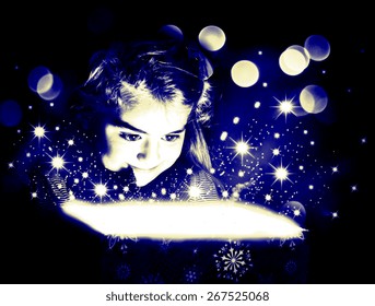 Child opening a magic gift box with lights and shining around