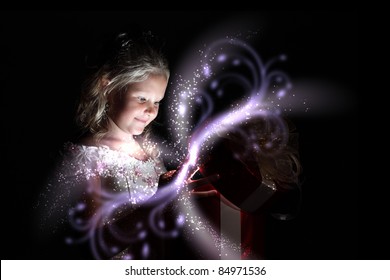 Child opening a magic gift box with lights and shining around - Powered by Shutterstock