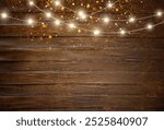 Christmas background with copy space. Top view of an empty rustic wooden table with string lights and bokeh