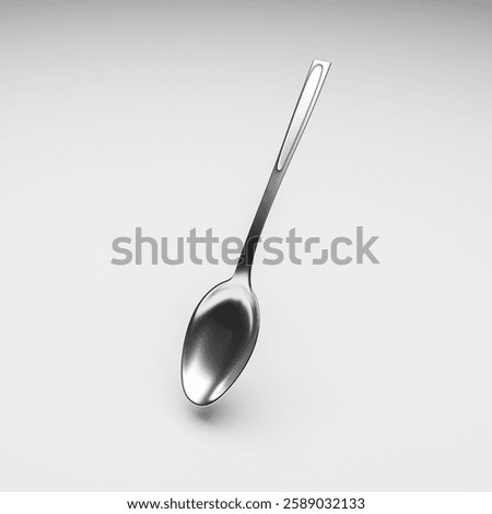 A chrome teaspoon on a grey table close-up.