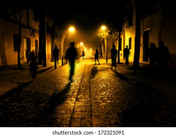 City At Night. Shadows Of People Walking Down The Street