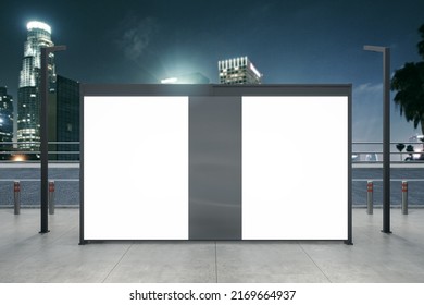 Clean White Bus Stop Billboard On Blurry Night City Background. Commercial And Ad Concept. Mock Up, 3D Rendering