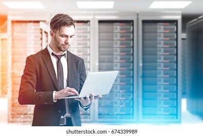 Close up of a bearded engineer standing with a laptop in a server room with polygons hologram behind him. 3d rendering mock up toned image double exposure