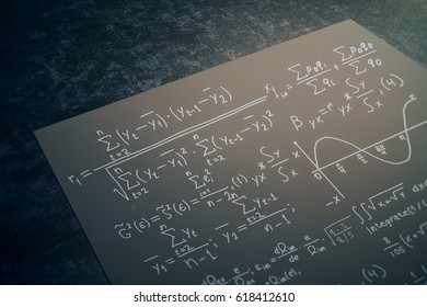 Close up of black paper sheet with mathematical formulas placed on dark desktop. Math concept. 3D Rendering