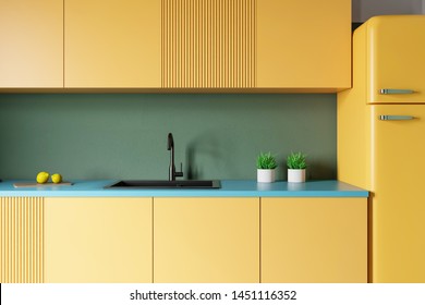 Close Up Of Kitchen Sink Built In Yellow Countertops With Yellow Cupboards Above It In Modern Room With Green Walls And Fridge. 3d Rendering
