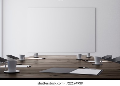 Close Up Of Wooden Meeting Table With Coffee Cup And Documents In Conference Room With Empty Banner On Concrete Wall. Mock Up, 3D Rendering 