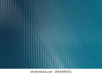 A close-up abstract background featuring a gradient of blue tones with a distinct vertical ribbed or corrugated pattern, creating a modern textured effect.
