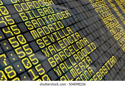 Close-up of an airport departure board to Spanish cities destinations, with environment reflection.Part of a series.