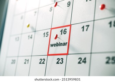 Close-up of a calendar highlighting a webinar on the 16th using a red pin, on a blurred background. Concept of event scheduling. 3D Rendering - Powered by Shutterstock