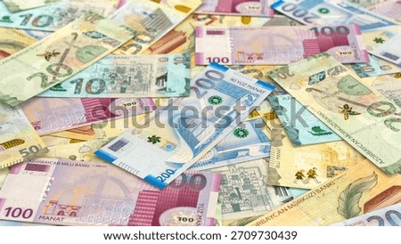 A close-up, full frame view of a large pile of scattered azerbaijani manat currency notes.