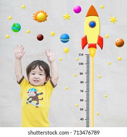 Closeup Happy Asian Kid Stand For Measure Height With Cute Cartoon At The Marble Stone Wall Textured Background In Growth Of Kid Concept