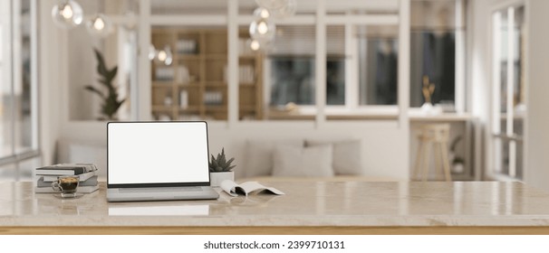 Close-up image of a white-screen laptop computer mockup, books, a coffee cup, and a potted plant on a desk in a modern beautiful living room. blurred background. 3d render, 3d illustration