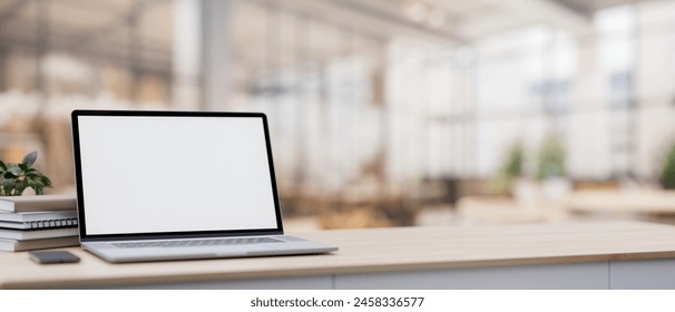 A close-up image of a white-screen laptop computer on a minimal wood table with a blurred background of a spacious luxurious cafe coffee shop or restaurant. 3d render, 3d illustration