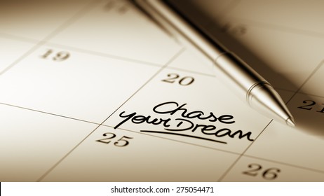 Closeup of a personal agenda setting an important date written with pen. The words Chase your dream written on a white notebook to remind you an important appointment.