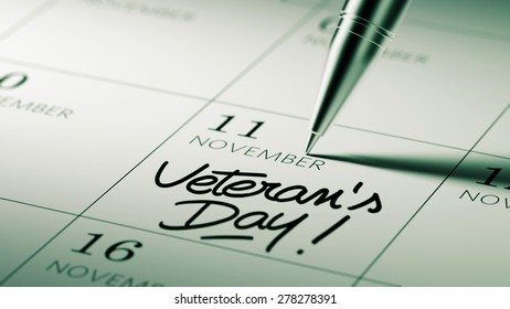 Closeup of a personal agenda setting an important date written with pen. The words Veteran's Day written on a white notebook to remind you an important appointment.