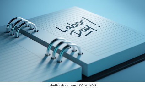Closeup of a personal agenda setting an important date representing a time schedule. The words Labor Day written on a white notebook to remind you an important appointment.