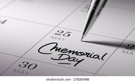 Closeup of a personal agenda setting an important date written with pen. The words Memorial Day written on a white notebook to remind you an important appointment.