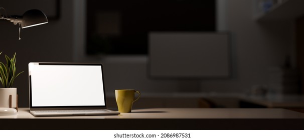 Close-up Portable Laptop Computer With Blank Screen Mockup And Copy Space On Table In Modern Dark Office Studio At Night. 3d Rendering, 3d Illustration