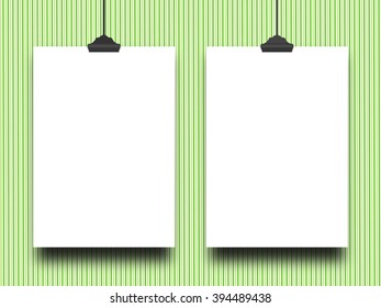 Close-up of two hanged blank frames with clips against green stripes background