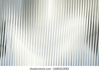 A closeup view of a textured surface with vertical ribbed patterns, creating a sense of depth and abstract visual interest with light and shadow