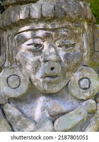 Closeup of a weathered, unidentified sculpture, maybe of an ancient deity, in dappled sunlight in a subtropical garden. Digital oil-painting effect, 3D rendering. For cultural and mythological motifs.