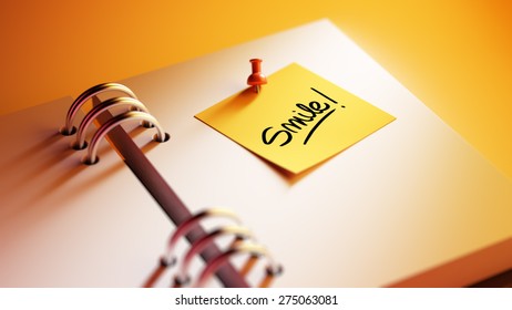 Closeup Yellow Sticky Note paste it in a notebook setting an appointment. The words Smile written on a white notebook to remind you an important appointment.
