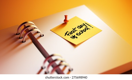 Closeup Yellow Sticky Note paste it in a notebook setting an appointment. The words First day of school written on a white notebook to remind you an important appointment.