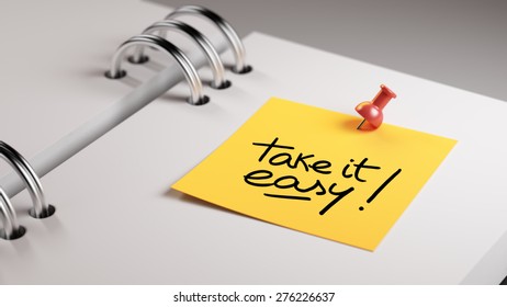 Closeup Yellow Sticky Note paste it in a notebook setting an appointment. The words Take it easy written on a white notebook to remind you an important appointment.