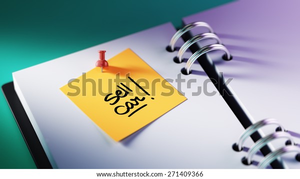Closeup Yellow Sticky Note paste\
it in a notebook setting an appointment. The words Sell Car written\
on a white notebook to remind you an important\
appointment.