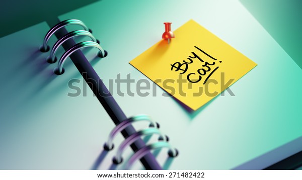 Closeup Yellow Sticky Note paste\
it in a notebook setting an appointment. The words Buy Car written\
on a white notebook to remind you an important\
appointment.