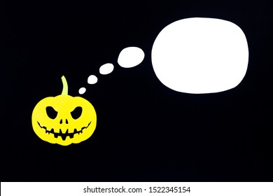 A colored background from a pumpkin cut out of orange paper isolated on a black background with a place for notes, ideal for the holiday of all saints - Halloween.
