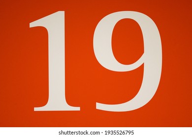 Colorful Red And White Sign With The Number Nineteen - 19 - Stencilled In The Centre In A Full Frame View