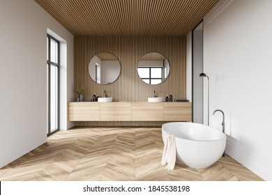 Comfortable bathtub and sink standing in modern bathroom with white and wooden walls and wooden floor. 3d rendering