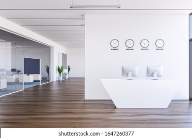 Comfortable reception desk in international company hall with white walls, clocks showing world time and waiting room with white armchairs in background. 3d rendering