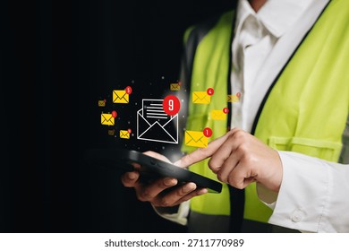 Communication alert concept, worker checking smartphone with email notification icons, workflow messaging management, timely response efficiency, operational coordination.