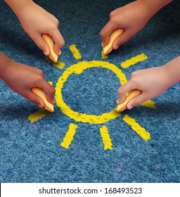 Community Education And Children Learning And Development Concept With A Group Of Hands Representing Ethnic Groups Of Young People Holding Chalk Cooperating Together As Friends To Draw A Yellow Sun.