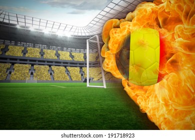Composite image of fire surrounding germany flag football against vast football stadium with fans in yellow